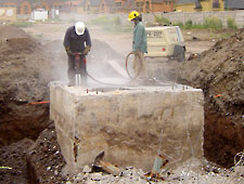 Workers drilling holes for Bustar expansive grout.